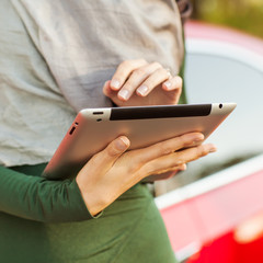 Woman using digital tablet PC in the park.