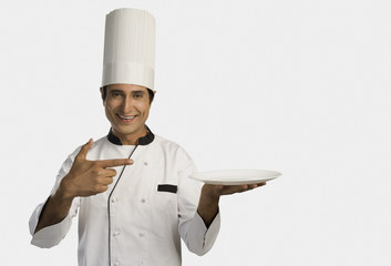 Portrait of a chef holding a plate and smiling