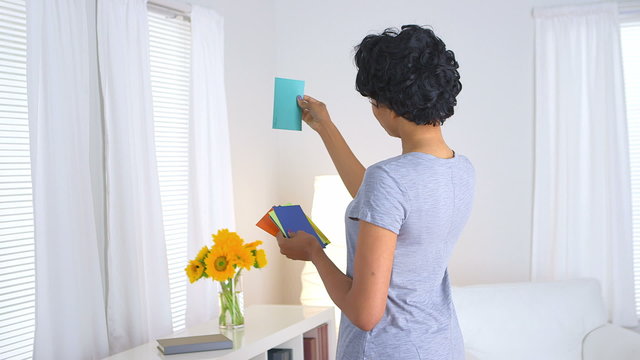 Black woman looking through paint chips