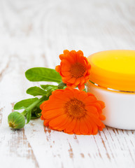 Face cream and calendula flowers