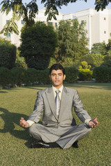 Businessman practicing yoga in a park