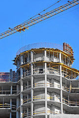 Fototapeta premium Crane and building construction site against blue sky