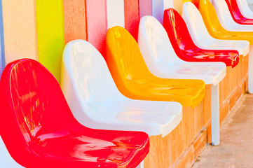 a number of multi-colored seats for children
