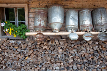 old milk cans on a shelve at a alpine hut