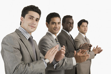 Portrait of four businessmen applauding