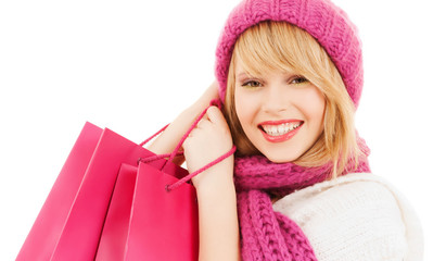 woman in pink hat and scarf with shopping bags