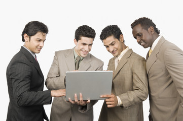 Four businessmen standing with a laptop