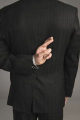 Fototapeta premium Businessman with fingers crossed behind his back