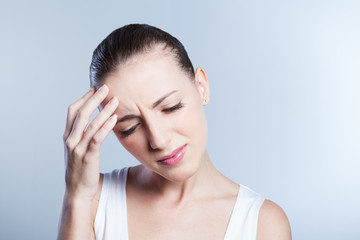 Woman having a headache holding her forehead in pain
