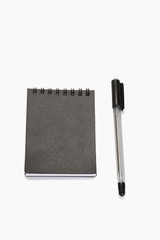 Close-up of a pen with a spiral notebook