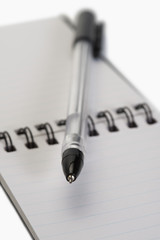 Close-up of a pen on a spiral notebook