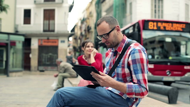 Young stylish man with tablet computer in the city