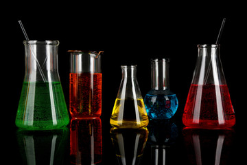 Test tubes with colorful liquids on dark grey background