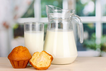 Pitcher and glass of milk with muffins