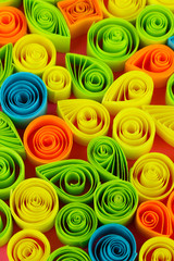 Colorful quilling on pink background close-up