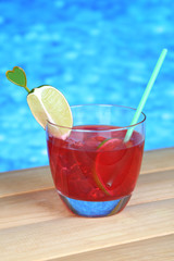 Tasty cocktail on swimming pool background