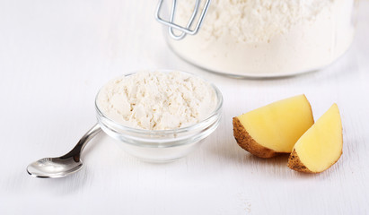 Starch in bowl and bank on wooden table close-up