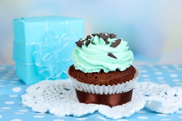 Tasty cupcake on table on light background