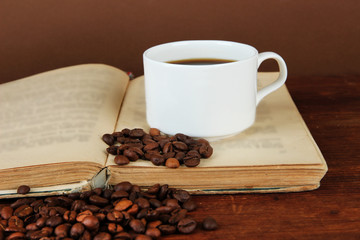 Cup of coffee with coffee beans and book