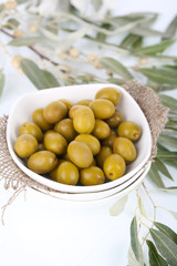 Olives in bowl with branch close up