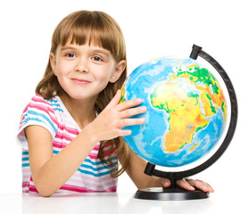 Little girl is examining globe