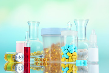 Medical bottles and pills on green background