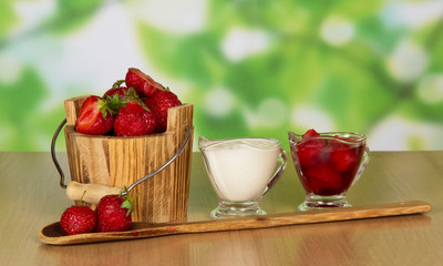 Strawberry in bucket and cup with cream