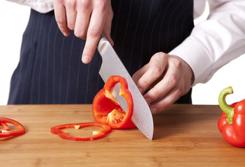 Young chef cutting bell peppers.