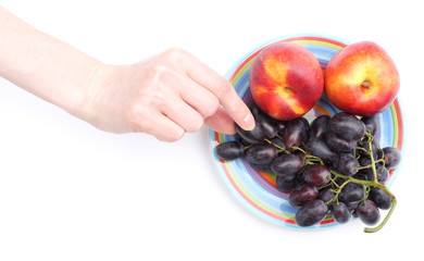 Hand and fruits on colorful plate