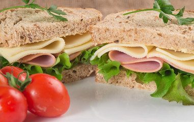 Fresh ham and cheese on white sandwich in rustic kitchen setting