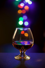 Glass of cognac and night bokeh background