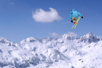 Jumping skier at jump inhigh mountains at sunny day