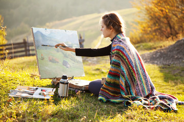 Young artist painting an autumn landscape - obrazy, fototapety, plakaty
