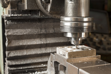 mill cutting the metal blank with cooling liquid