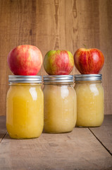 Jars of homemade applesauce with apples