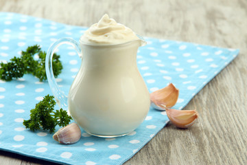Sour cream in pitcher on table close-up