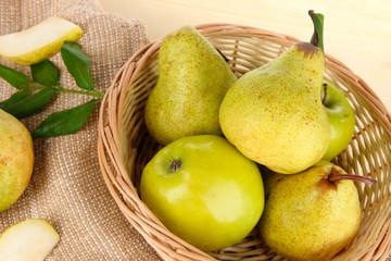 Pears in basket on burlap on wooden table