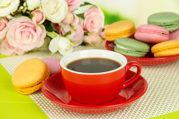 Coffee and macaroons on table on light background