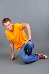 Handsome young man dancing on grey background