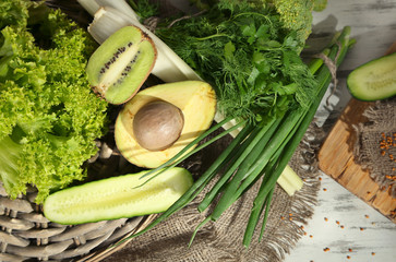 Fresh green vegetables and fruits, on wooden background © Africa Studio