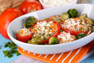 Stuffed tomatoes in bowl on wooden table close-up