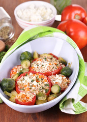 Stuffed tomatoes in bowl on wooden table close-up