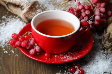 Still life with viburnum  tea in cup, berries and snow,
