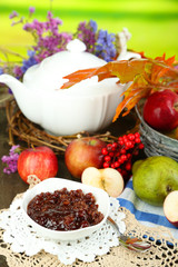 Juicy apples in basket on table on natural background