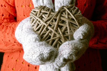 Female hands in mittens with heart, close-up