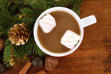 Cup of hot cacao with chocolates on wooden background