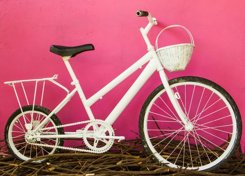 white bicycle on pink wall