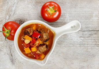 Top view of red soup with fresh vegetables and meat