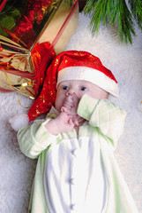 Small breast child near new year's fir tree with gift