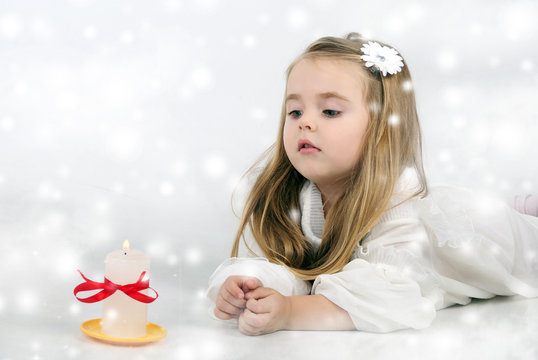 A beautiful little girl angel with a candle